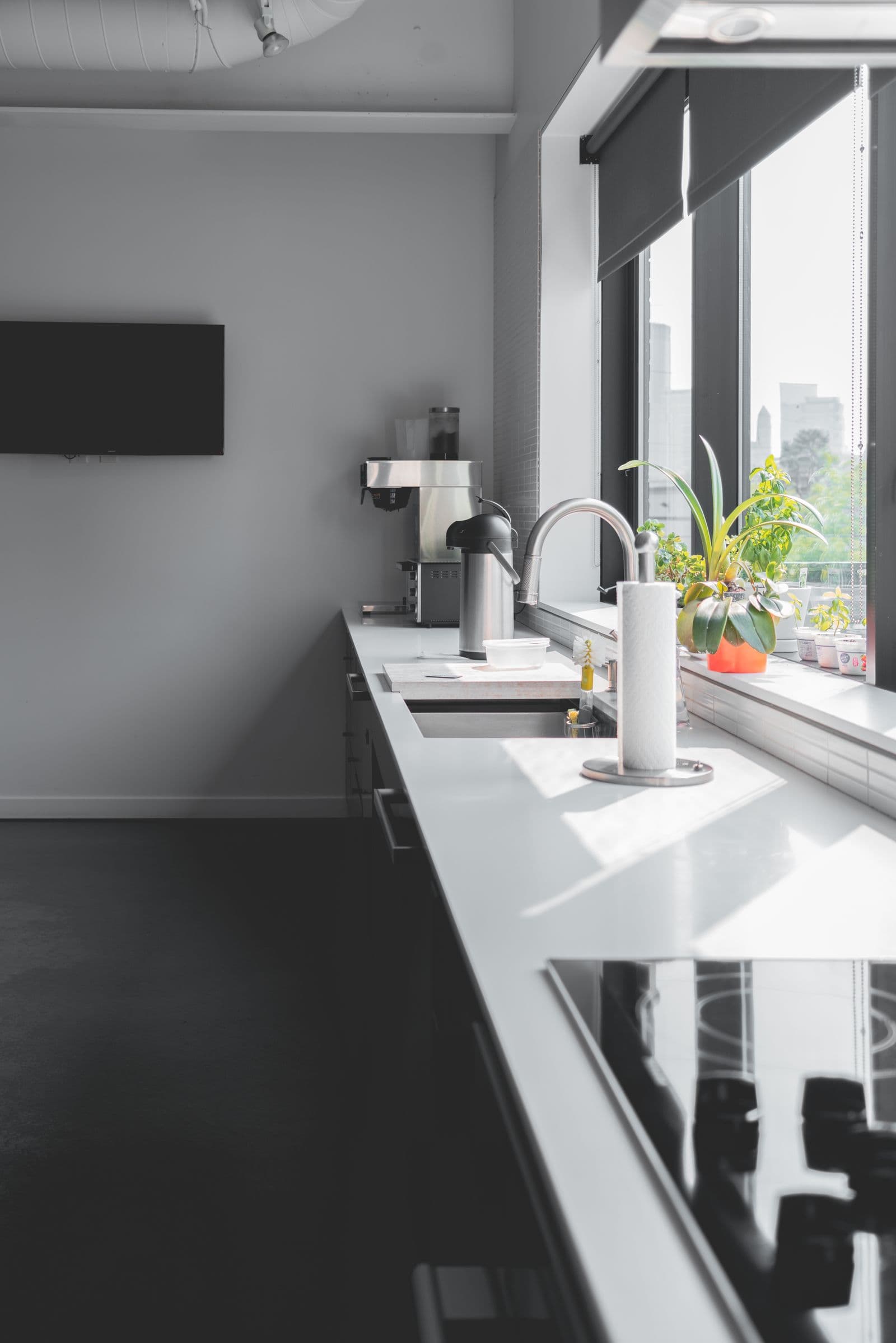 A sunlit kitchen bench by large windows