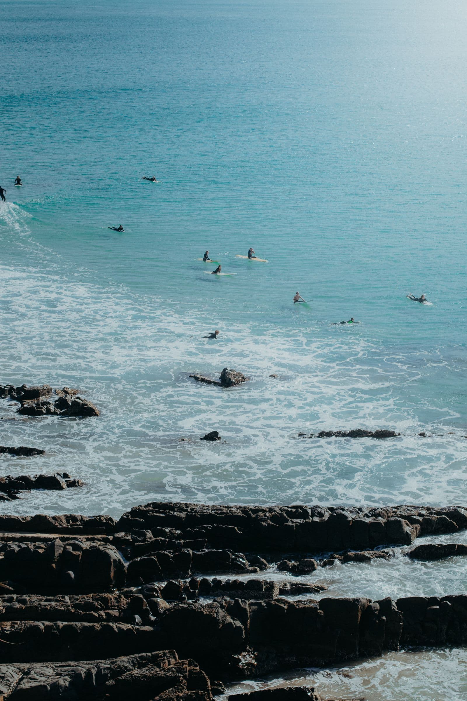 Surfers in turquoise water at Crescent Head, seen from above